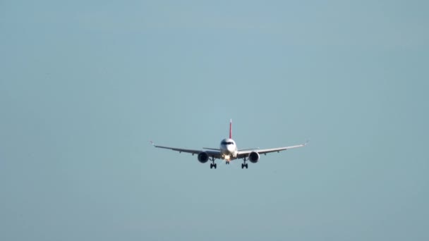 Vliegtuig nadert de landingsbaan onder heldere hemel. — Stockvideo