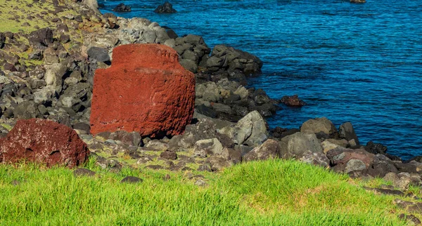 Bright red Moai statue pukao near ocean — Stockfoto