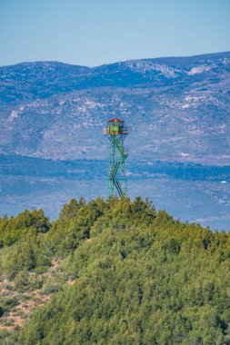 Tepedeki yangın gözetleme kulesinde arka planda dağlar var.