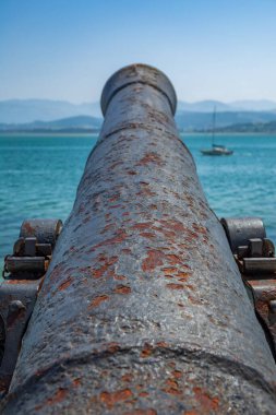 Bulanık tekneyle denize bakan antika eski toplar.
