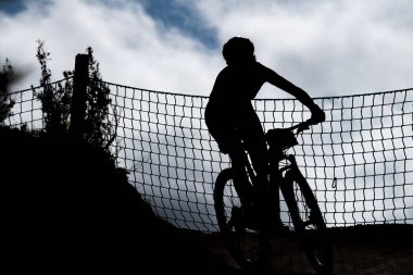 Dağ bisikletçisi silueti ağ ile virajda