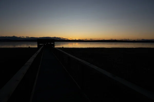 Západ slunce s jezerem, kabinou a tratí s jasnou oblohou — Stock fotografie