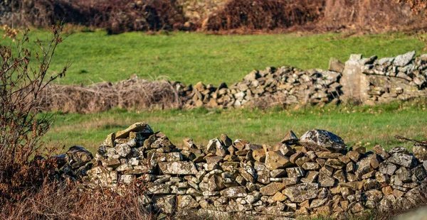 Vintage stone walls and bright green fields — Stock Photo, Image