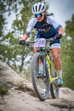 Paola Fernandez, MTB şampiyonasında kayaların üstünde.