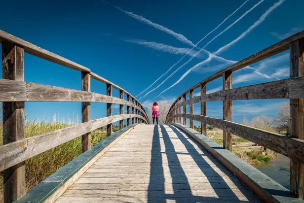 Vrouw in roze kleren over houten brug — Stockfoto