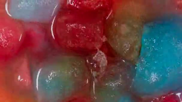 Ice in different colors melting into red — Stock Video