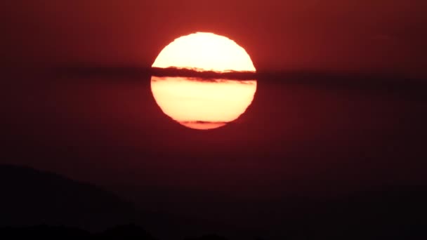Огромное яркое солнце за облаками на закате — стоковое видео