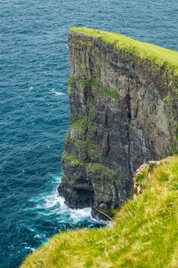 Küçük turistlerle okyanusun üzerinde yüksek uçurumlar