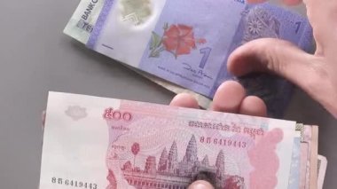 Farklı ülkelerden gelen faturaları cama fırlatıyor.