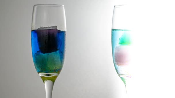 Two glasses with colorful ices melting — Stock Video