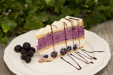 Böğürtlen ve beyaz beyaz bir tabağa Çikolata pasta dilimi