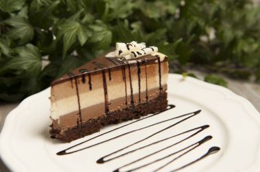 Üç farklı çikolata ile ev yapımı çikolatalı pasta dilimi