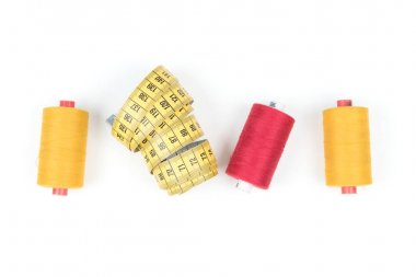 Beyaz arka plan, tekstil arka plan veya duvar kağıdı kasede ölçme sarı ile kırmızı iplik bobin dikiş