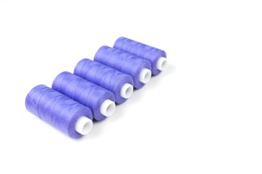 Dikiş ve terzilik ve aksesuarlar beyaz bir arka planda, beş mor dikiş ipliği