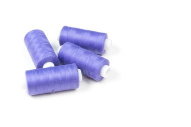 Dört mor dikiş ipliği ve aksesuarlar dikiş beyaz bir arka plan üzerinde