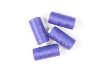 Dört mor dikiş ipliği ve aksesuarlar dikiş beyaz bir arka plan üzerinde