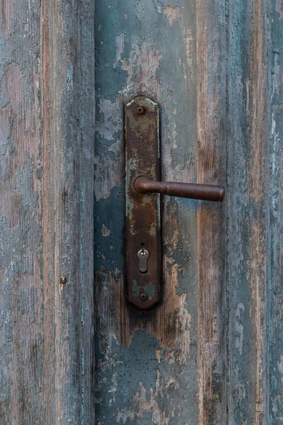 Eski mavi ahşap kapılar üzerindeki eski vintage metal kapı kolu. Paslı kapı kolu