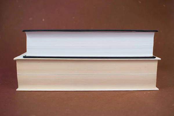 Twee Hardback Boeken Elkaar Gestapeld Bruine Achtergrond Oppervlakte — Stockfoto