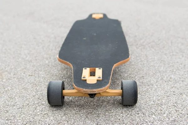 Image of wooden longboard with black surface. Street transportation.