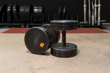 İki eski ve kullanılan spor salonu siyah metal dambıl. Spor salonu ve fitness ekipmanları