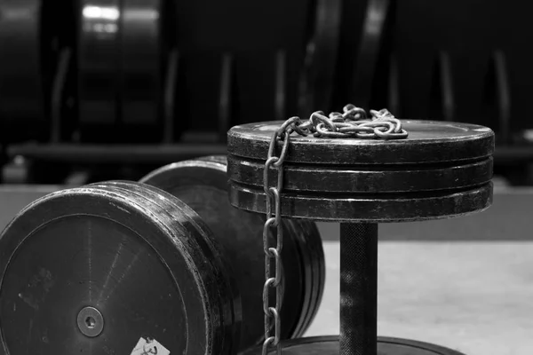 Gümüş Zincir ile iki eski ve kullanılan spor salonu siyah metal dambıl. Spor salonu ekipman