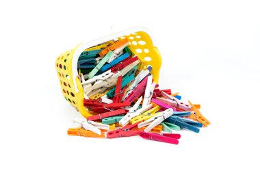 Beyaz arka plan üzerinde izole sarı sepet içinde renkli plastik bez kelepçeler yığını.