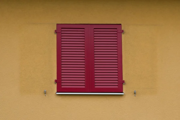 Rote Holzläden Einem Gebäude Mit Gelb Gestrichenen Wänden — Stockfoto