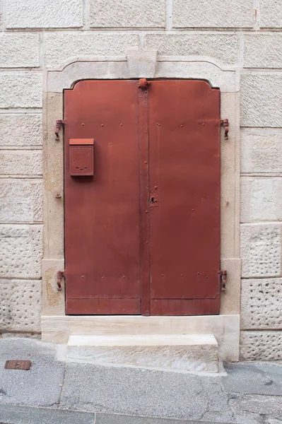 石の壁に古い金属製の赤いドアの家します 小さなメールボックスに赤い金属製のドア エクステリア デザイン 大理石で作られた壁 — ストック写真