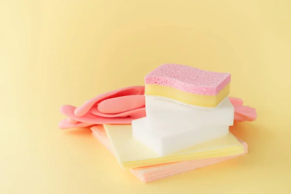 Set hulpmiddelen voor het reinigen van roze handschoenen en sponzen, op een gele b — Stockfoto
