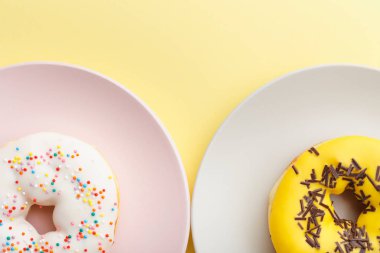 bir sarı arka plan, yakın çekim, üstten görünüm üzerinde bir tabakta donut