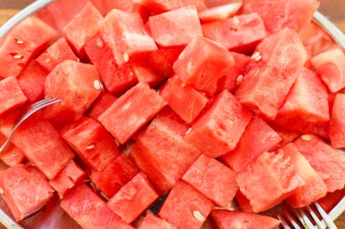 Güneş ışığı altında ahşap arka plan üzerinde tatlı çatal ile a demet-in dilim dilimlenmiş sulu karpuz ile oval çanak metal, yakın çekim, görünümü ana sayfa