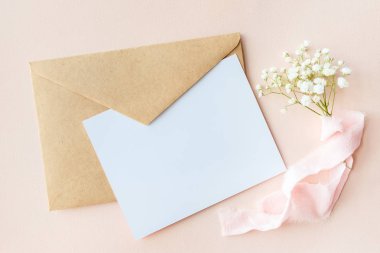 İpek kurdele, davetiye düğün, bir metni kartı ve bir zarf ile Gypsophila pembe bir zemin üzerine bir mektup
