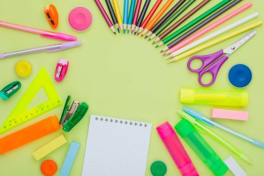 ileti örneği arka planı yeşil, çok renkli boyalar, kalemler, işaretçileri, silgi, cetvel, kalemtıraş, makas, zımba üzerinde bir sürü. Çocuklar okul için hazırlık kavramı. Kopya alanı.