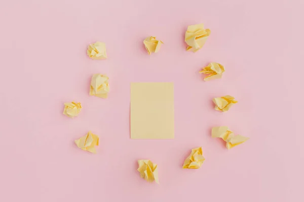 Un montón de pegatinas amarillas arrugadas de papel, esparcidas sobre un fondo rosa, en el centro de una sábana limpia. estilo de oficina — Foto de Stock