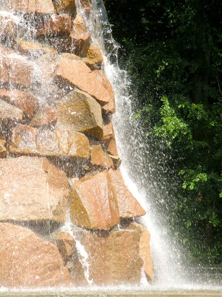 Parkta şelale, taşlardan aşağı su akıyor.