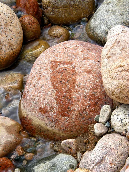 stones on the river bank with a wet footprint