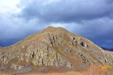 Taygadaki Rocky Dağı. Güneş tarafından aydınlatılan dağ bulutların arka planına karşı.