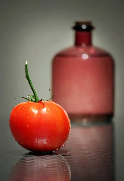 Botella de vidrio y tomate rojo — Foto de Stock