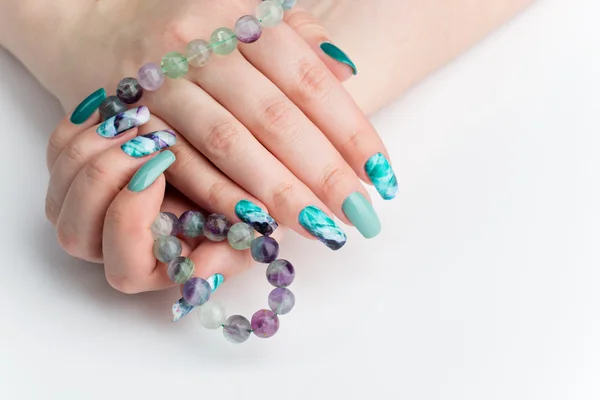 Gros plan de mains de femme avec des ongles colorés — Photo