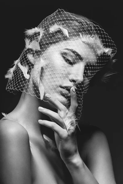 Beautiful girl in veil with feathers
