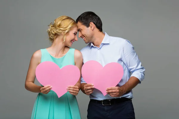 Belo casal segurando corações rosa — Fotografia de Stock