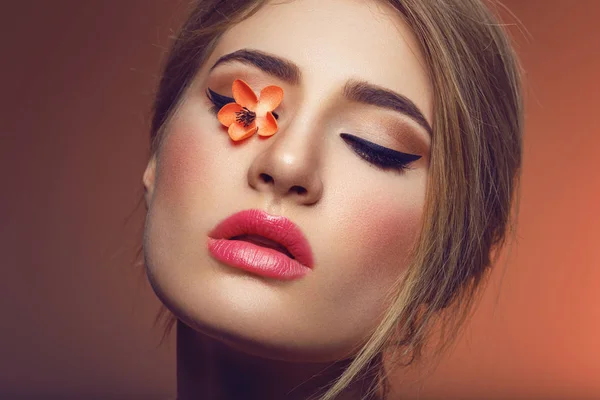 Vacker flicka med sakura blomma på ögat — Stockfoto