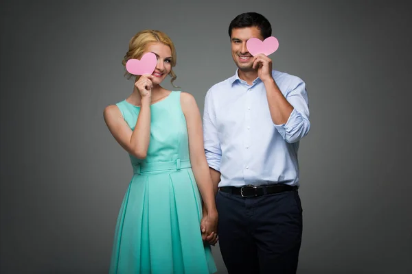 Belo casal segurando corações rosa — Fotografia de Stock