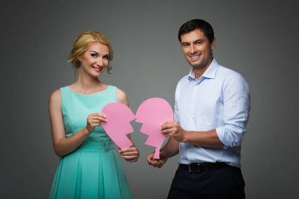 Hermosa pareja sosteniendo corazón roto rosa — Foto de Stock