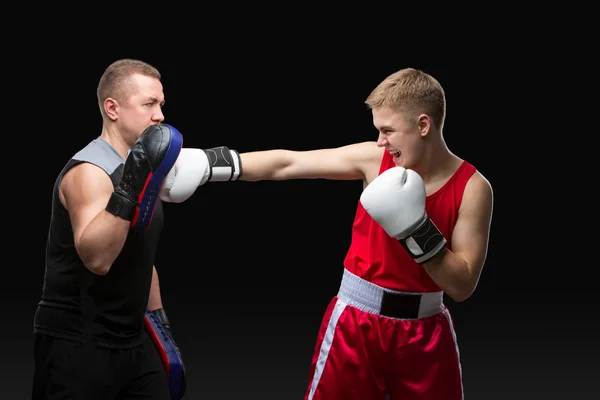 Joven boxeador haciendo ejercicio con el entrenador —  Fotos de Stock