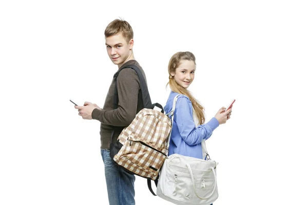 Teen chłopiec i dziewczyna stojąc z telefonów komórkowych — Zdjęcie stockowe