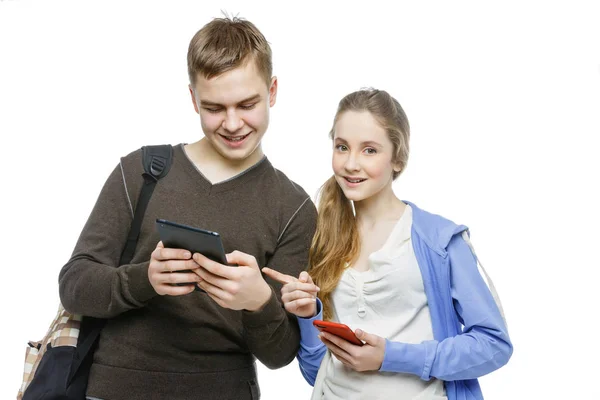 Adolescente menino e menina de pé com telefones celulares — Fotografia de Stock