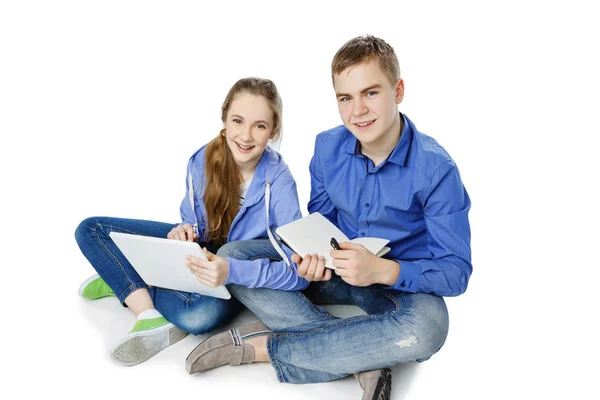 Teen age boy and girl with tablet and notebook — Stock Photo, Image