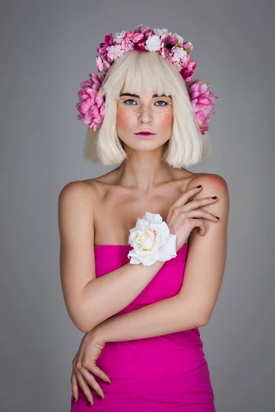 Krásná dívka v růžových šatech s květinovým hlavy příslušenství — Stock fotografie