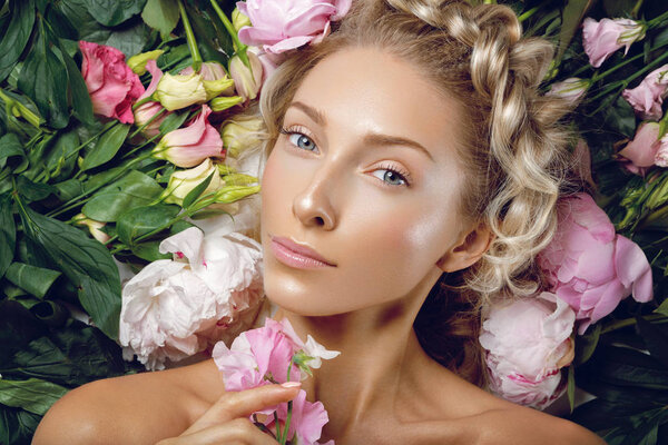 Beautiful girl lying in flowers